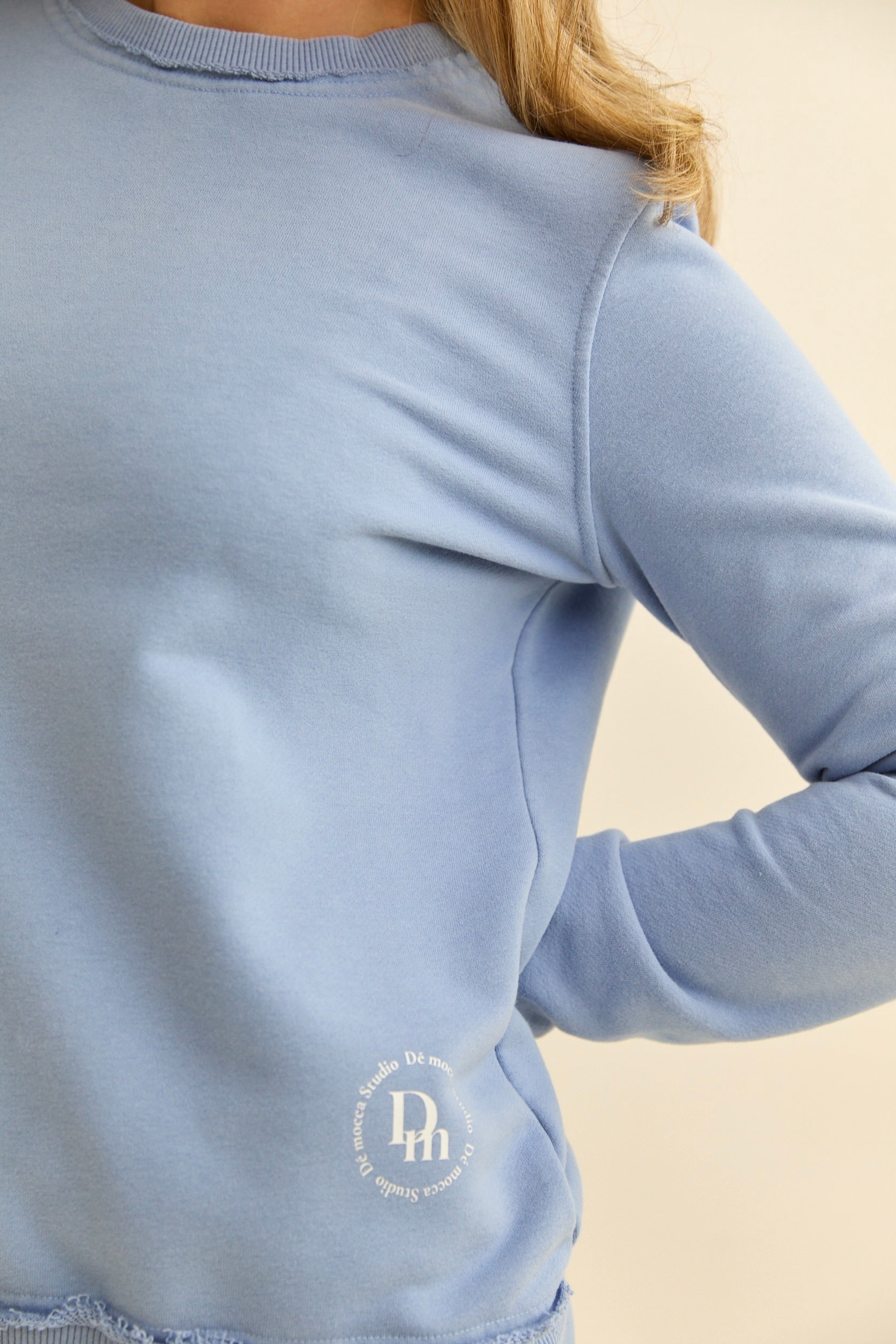 our timeless sweatshirt, simple as that and goes with everything. We added little rips on the neckline and ribbed sleeve cuffs to add dimension. With the DM logo in the lower part. blue